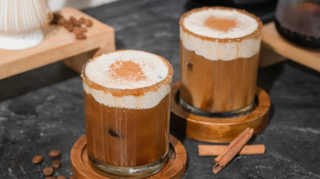 Es kopi dengan foam creamy dan taburan kayu manis, dibuat menggunakan krimer nabati untuk tekstur yang lembut dan emulsifikasi yang stabil