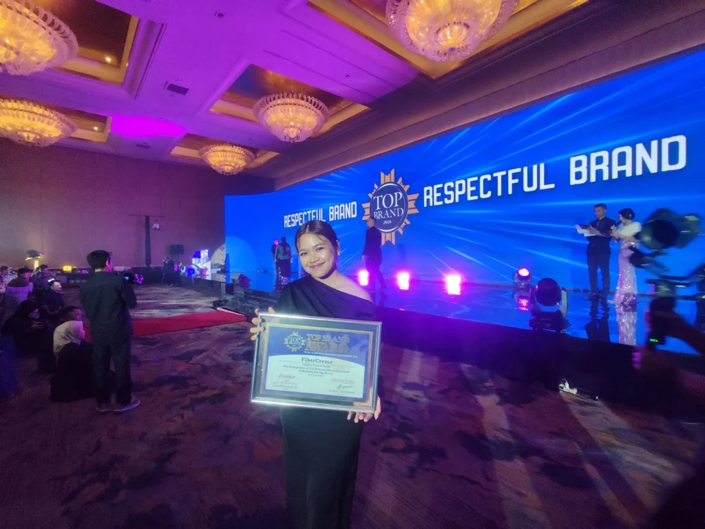 Priscillia Fabiola, Head of Brand of PT Lautan Natural Krimerindo, holds the Top Brand Award 2026 plaque