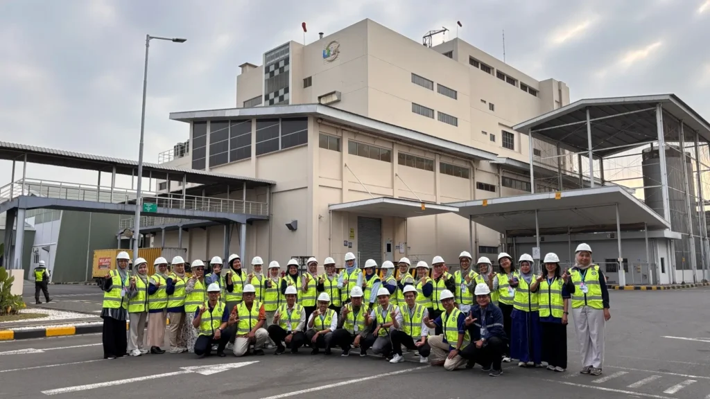 Participants of the Institut Supply Chain & Logistic Indonesia CAMP 2026 pose for a group photo at the PT Lautan Natural Krimerindo (LNK) factory area