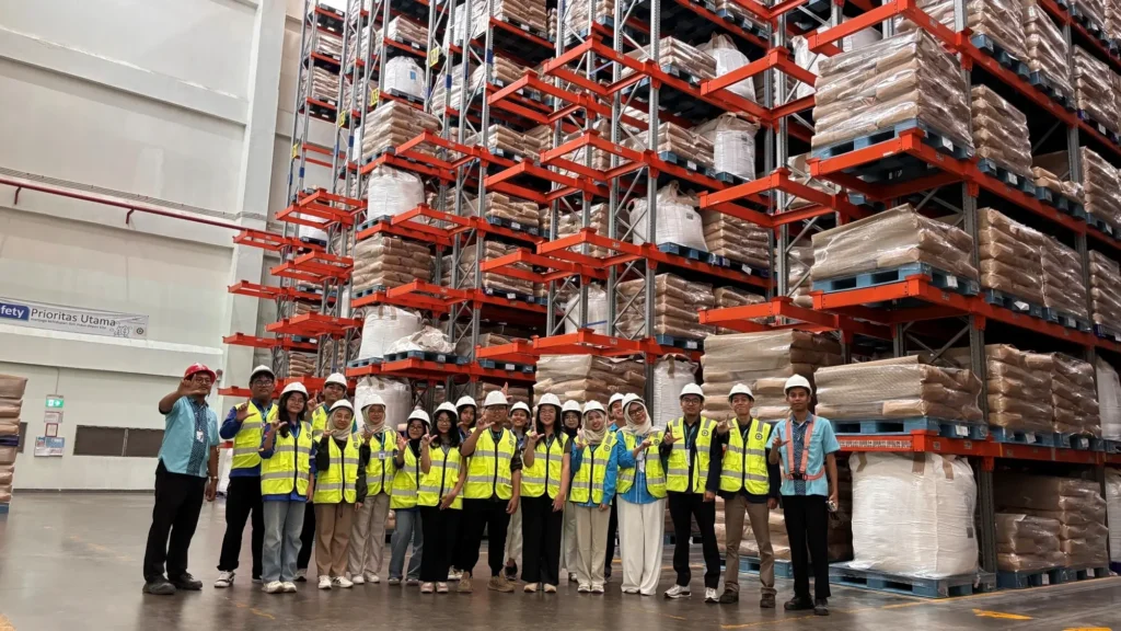 CAMP 2026 participants pose for a group photo in the warehouse area of PT Lautan Natural Krimerindo (LNK)